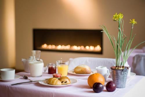 a table topped with plates of food and orange juice at Hotel Le Clos des Récollets in Durbuy