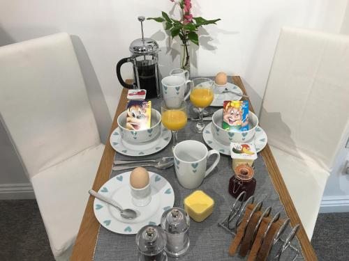 a table with breakfast food and eggs on it at Almondsbury Luxury Apartment in Almondsbury