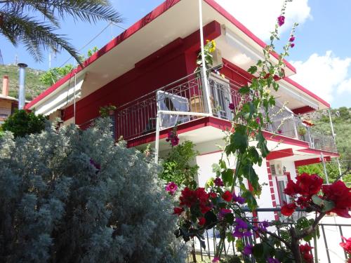 a red and white house with flowers in front of it at Elena Rista Studios in Parga