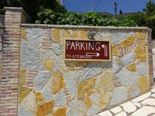 a sign on the side of a stone wall at Elena Rista Studios in Parga
