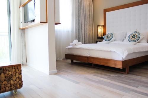 a bedroom with a large bed and a television at Yarden Estate Hotel in Yesod Hamaala