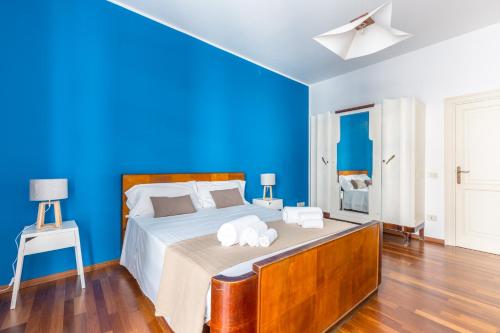 パレルモにあるPiazza Marina Holiday House by DomuSicilyの青いベッドルーム(タオル付きのベッド付)