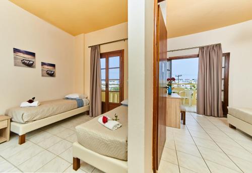 a bedroom with two beds and a balcony at Villa Diasselo in Malia