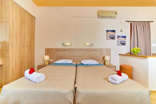a bedroom with two beds with towels on them at Villa Diasselo in Malia
