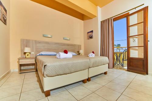 a bedroom with a bed and a balcony at Villa Diasselo in Malia