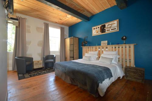 a bedroom with a large bed with blue walls at Moulin De Jouenery Et Spa in Brassac
