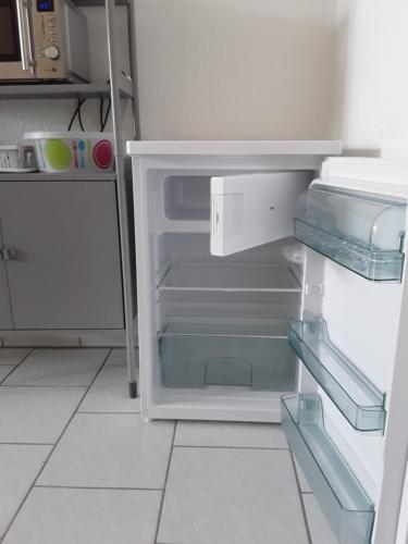 an empty refrigerator with its door open in a kitchen at Pension zum Bauhof in Zwickau