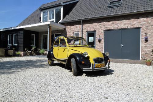 a yellow car parked in front of a house at Bed&Breakfast Hoornaar in Hoornaar