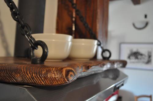 a wooden table with two white bowls on a chain at Apartments Oliva in Fiorini