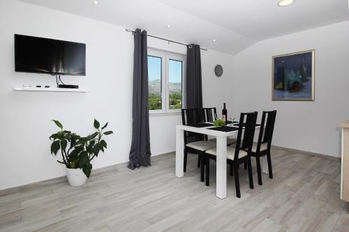 a dining room with a white table and chairs at Apartments Močići in Močići
