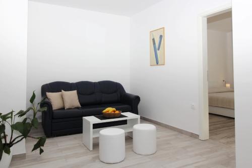 a living room with a black couch and a table at Apartments Močići in Močići
