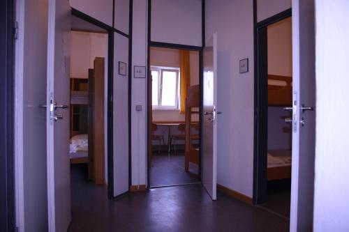 a hallway with doors and a room with a table at Jugendherberge Otto-Moericke-Turm in Konstanz