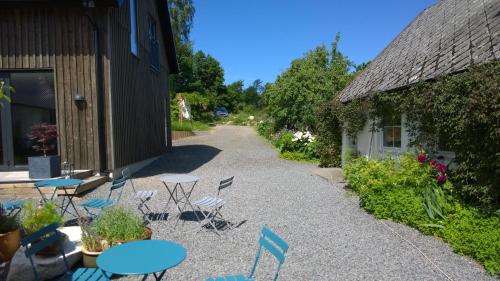 a patio with tables and chairs next to a building at Elisetorp in Kivik