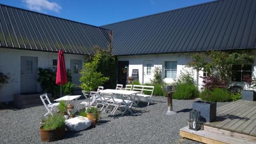 a patio with a table and chairs in front of a building at Elisetorp in Kivik