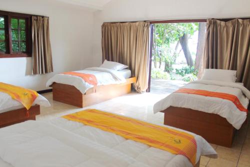 a bedroom with two beds and a large window at Seribu Resort Thousand Island in Kepulauan Seribu