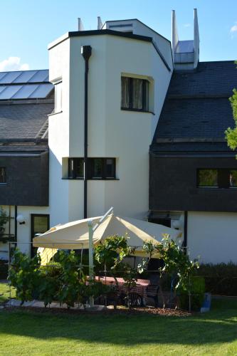 a white building with a table and a white umbrella at Hotel Leitgebhof in Innsbruck