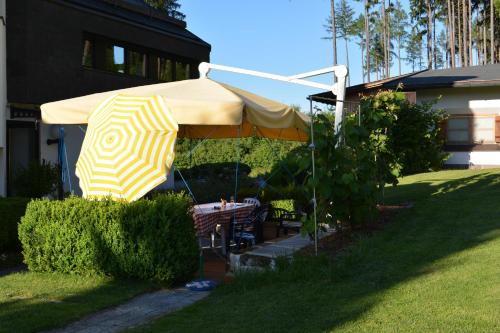 a yellow and white umbrella in a yard at Hotel Leitgebhof in Innsbruck