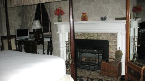 1 dormitorio con chimenea y 1 cama. en A Cambridge House Inn en Cambridge