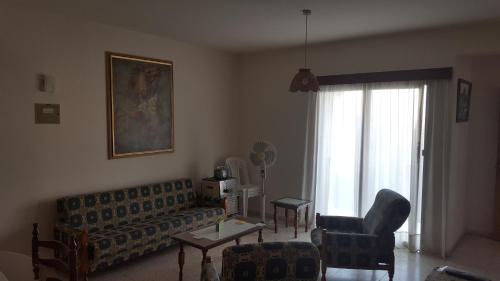 a living room with a couch and chairs and a window at Chariandry Court in Pissouri