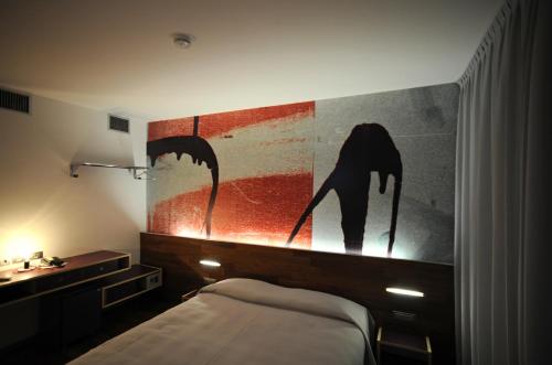 a bedroom with a bed and a painting on the wall at Alloggi Taverna Caorlina in Caorle
