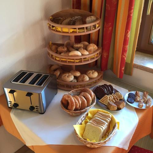 a table topped with plates of pastries and a shelf of donuts at Gästehaus am Graben in Reutte