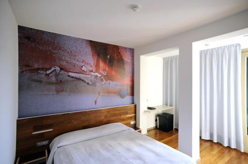 a bedroom with a bed and a painting on the wall at Alloggi Taverna Caorlina in Caorle