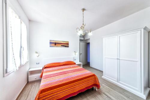 a bedroom with a bed with an orange blanket at Isola Antica in SantʼAntìoco