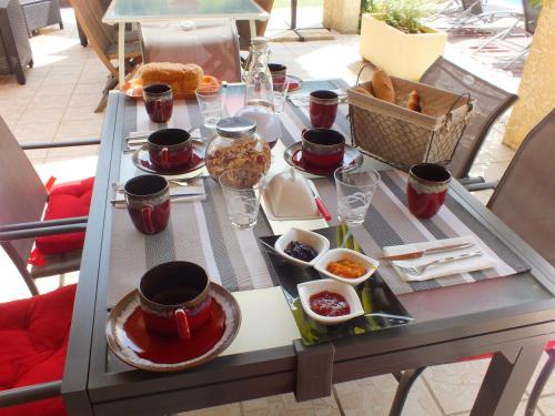 a table with plates of food and drinks on it at B&B Le Mas Des Chenes in Vacquières