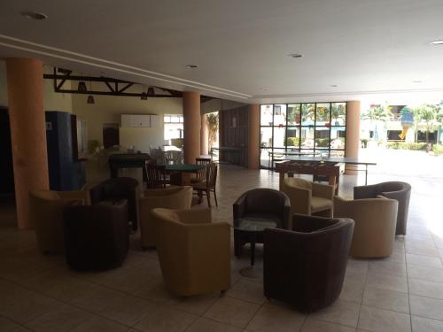 a restaurant with tables and chairs in a room at CONDOMÍNIO VILA DO MAR in Aquiraz