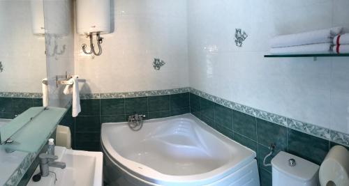a bathroom with a tub and a toilet and a sink at Sea House Mljet in Polače