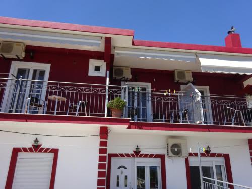 a red and white building with a balcony at Elena Rista Studios in Parga