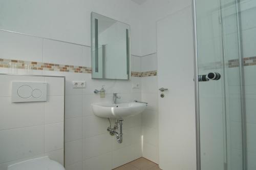 a bathroom with a sink and a toilet and a mirror at Ferienwohnung Sonneneck in Scharzfeld