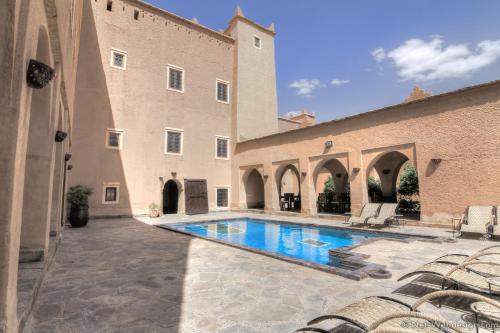 un patio con piscina al lado de un edificio en Kasbah Imdoukal, en Nkob