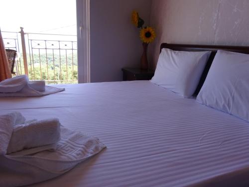 a bedroom with a bed with white sheets and pillows at Elena Rista Studios in Parga