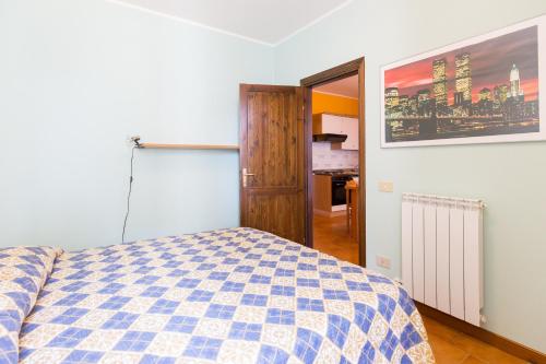 リド・ディ・スピーナにあるAppartamento Pucciniのベッドルーム(青と白のチェッカーベッド付)