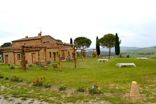 an old building in a field with a park at Agriturismo Il Casalino in Pienza
