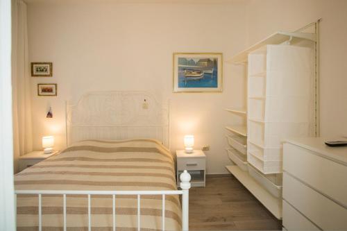 a white bedroom with a bed and two lamps at Apartment Splendido in Split
