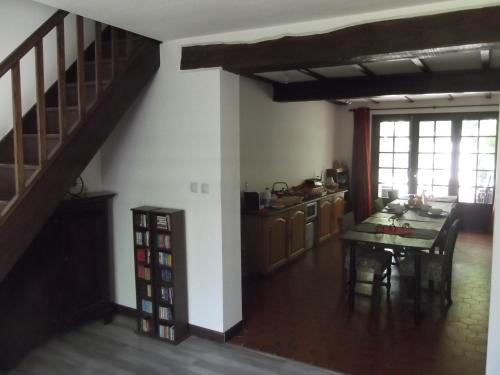 - une cuisine et une salle à manger avec une table et des escaliers dans l'établissement 43 Rue des Quarts, à Ménesplet