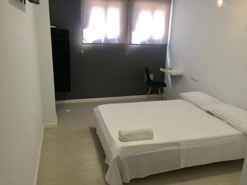 a bedroom with a white bed and two windows at SolRoom (plz. La Nogalera) in Torremolinos