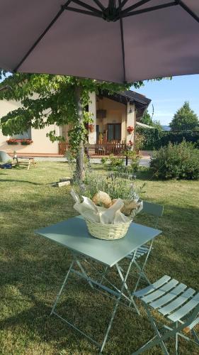 a picnic table with a basket and an umbrella at Agriturismo Ca' di Mazza in Monzuno