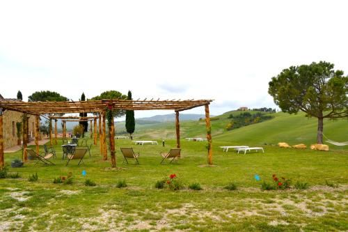 a gazebo with chairs and tables in a field at Agriturismo Il Casalino in Pienza