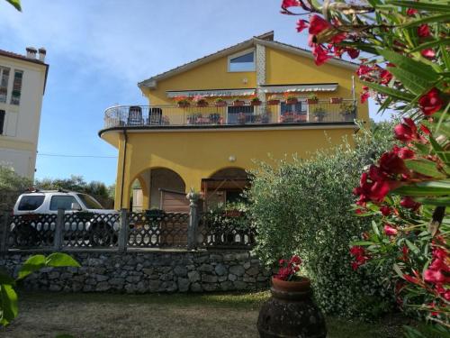 Una casa amarilla con balcón en la parte superior. en B&B Mare e Monti, en La Spezia