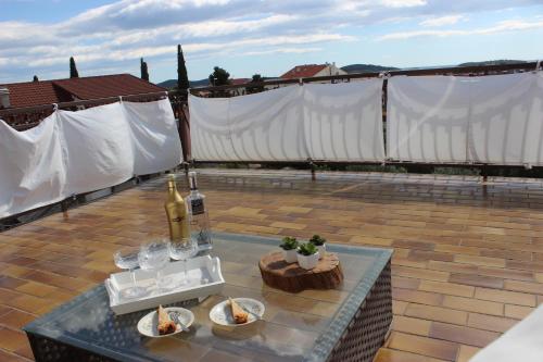 ein Tisch mit Weingläsern und Speisen auf einem Dach in der Unterkunft Apartment Floral in Brodarica