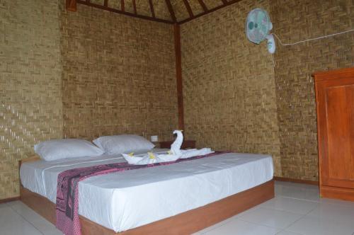a bed with a stuffed animal sitting on top of it at Airas' Garden Homestay ECO Bungalows in Kuta Lombok