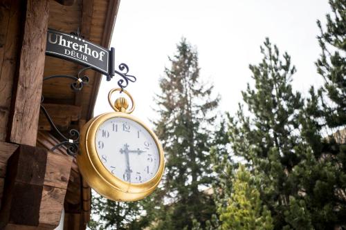a clock hanging on the side of a building at Charmehotel Uhrerhof - Deur in Ortisei