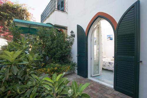 an entrance to a house with green doors and plants at Villa al Porto in Ischia