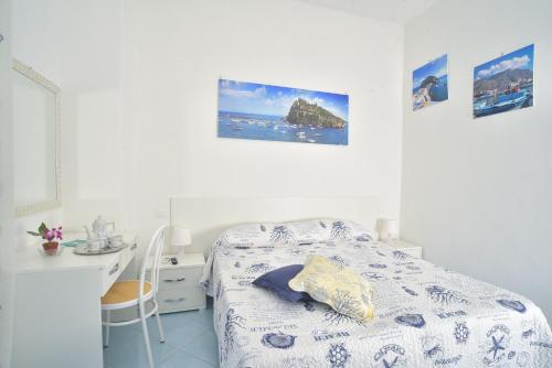 a white room with a bed and a desk at Villa al Porto in Ischia