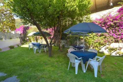 a group of tables and chairs with umbrellas at Villa al Porto in Ischia