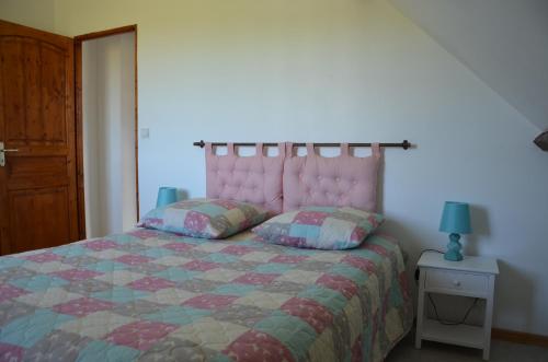 a bedroom with a bed with a pink headboard and two pillows at la ferme fleurie in Echinghen