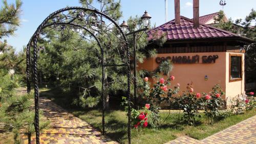 um arco de jardim em frente a um edifício com flores em Villa Sosnovy Bor em Zatoka